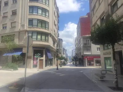 an empty street in a city with tall buildings at Piso da Ulla in A Estrada