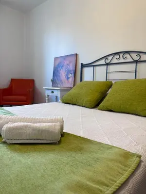a bedroom with a large bed with green pillows at Suite Rigel in Ponferrada