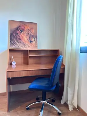 a desk with a blue chair and a picture of a lion at Suite Rigel in Ponferrada