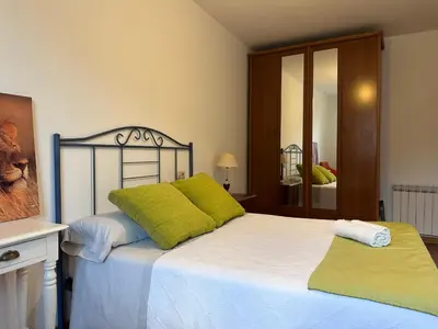 a bedroom with a bed with green pillows on it at Suite Rigel in Ponferrada