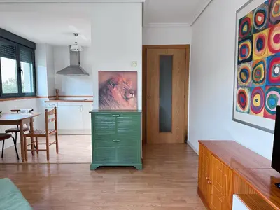 a living room with a green dresser and a table at Suite Rigel in Ponferrada