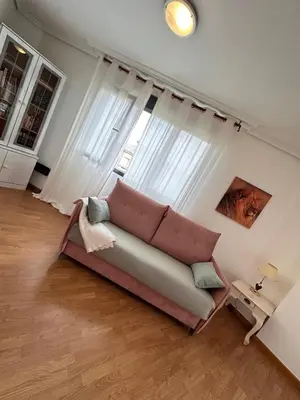 a couch in a living room with a large window at Suite Rigel in Ponferrada