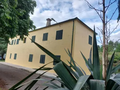 a yellow building with a chimney on top of it at Ás Portas do Sil - En la Ribeira Sacra in Villar de Cerreda