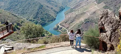 two girls standing on a suspension bridge over a river at Ás Portas do Sil - En la Ribeira Sacra in Villar de Cerreda