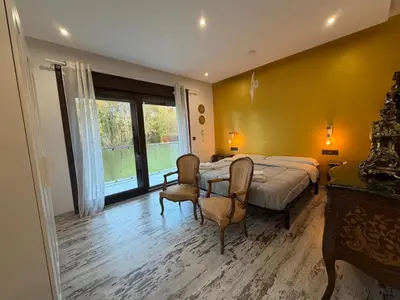 a bedroom with a bed and two chairs and a window at Villa de la paz Ribeira Sacra in Monforte de Lemos