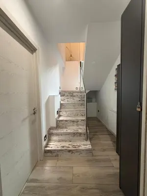 a hallway with a staircase with wooden floors and white walls at Villa de la paz Ribeira Sacra in Monforte de Lemos
