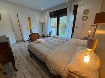 a bedroom with a large bed and a large window at Villa de la paz Ribeira Sacra in Monforte de Lemos