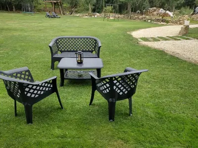 three benches and a table in the grass at Villa de la paz Ribeira Sacra in Monforte de Lemos