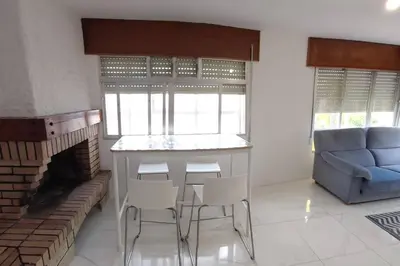 a living room with a fireplace and a blue couch at Casa Ricardo (16km de Coruña) in Castro