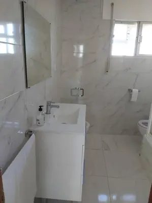 a white bathroom with a sink and a mirror at Casa Ricardo (16km de Coruña) in Castro