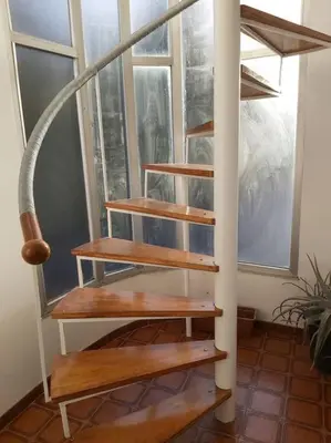 a wooden spiral staircase in a room with a window at Casa Ricardo (16km de Coruña) in Castro