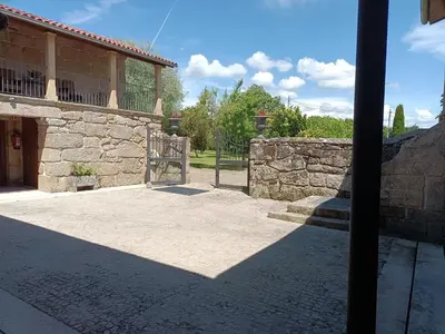 a building with a gate and a stone wall at Casa das Capelas in Villamarín