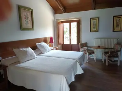 a hotel room with two beds and a table and a table at Casa das Capelas in Villamarín