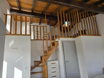 a staircase in a room with wooden ceiling at A de Féliz Ribadeo in Ribadeo