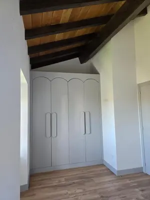 a room with white cabinets and a wooden ceiling at A de Féliz Ribadeo in Ribadeo