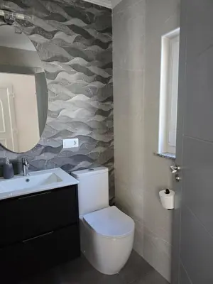 a bathroom with a toilet and a sink and a mirror at A de Féliz Ribadeo in Ribadeo