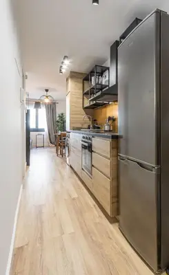 a kitchen with a stainless steel refrigerator and wooden floors at Maior 5 Apartamentos in Verín