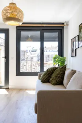 a living room with a couch and a large window at Maior 5 Apartamentos in Verín