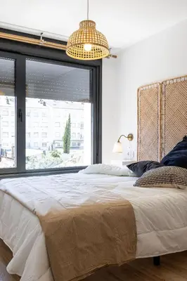 a bedroom with a large bed with a large window at Maior 5 Apartamentos in Verín