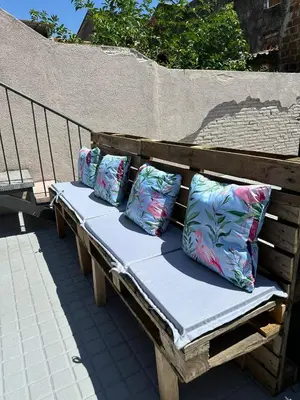 a wooden bench with four pillows on it at Maior 5 Apartamentos in Verín