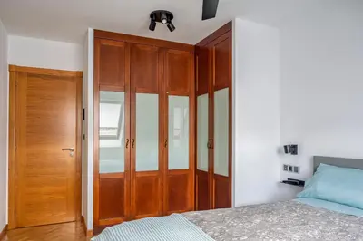 a bedroom with a wooden closet and a bed at Ático en Sada in Sada