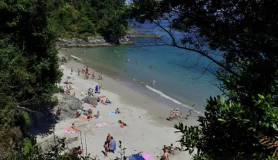 a group of people on a beach in the water at Ático en Sada in Sada