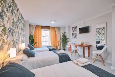 a hotel room with two beds and a desk at Peregrina Pensión 5 in O Pedrouzo