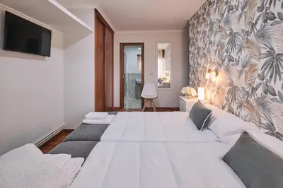a bedroom with a large bed and a wall with a mural at Peregrina Pensión 5 in O Pedrouzo