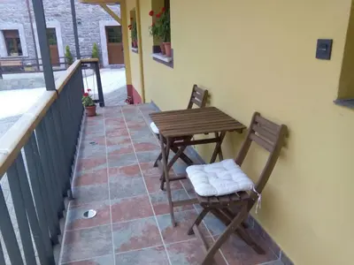 two chairs and a table on a balcony at Apartamentos rurales La Veiga in La Riera