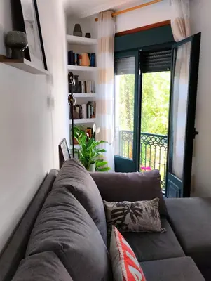 a brown couch in a living room with a window at Campo da Torre in Caldas de Reis