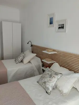a bedroom with two beds and a wall at Campo da Torre in Caldas de Reis