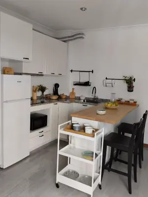 a kitchen with white cabinets and a table with chairs at Campo da Torre in Caldas de Reis