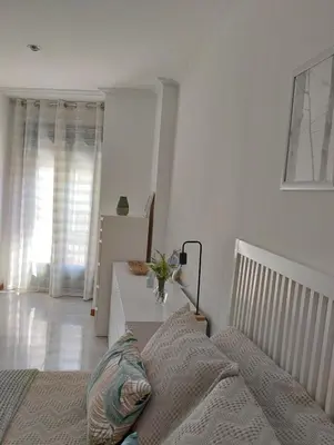 a white bedroom with a bed and a table at Campo da Torre in Caldas de Reis