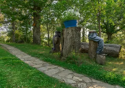 two statues of people sitting on a park bench at Cabañas de Madera Sanabria in Vigo de Sanabria