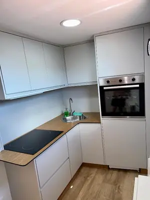 a kitchen with white cabinets and a sink and a microwave at N&E - Home Celanova Rúa Manuel Lezón in Celanova