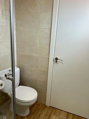 a bathroom with a toilet and a shower door at N&E - Home Celanova Rúa Manuel Lezón in Celanova