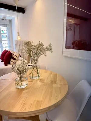 a dining room table with two vases of flowers on it at N&E - Home Celanova Rúa Manuel Lezón in Celanova