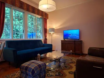 a living room with a blue couch and a tv at Oasis Ponte San Lázaro in Santiago de Compostela