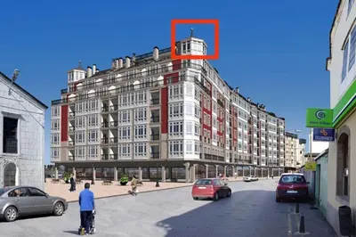 a man standing in a parking lot in front of a building at Apartamento de vacaciones in Ribadeo