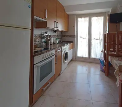 a kitchen with a stove and a washing machine at Apartamento de vacaciones in Ribadeo