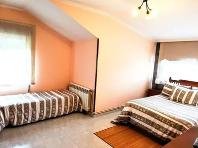 two beds in a room with orange walls at Apartamento en las afueras in Ribadeo