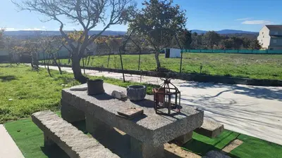 a stone bench in a park with a field at “Casa abella “ in Monterrei