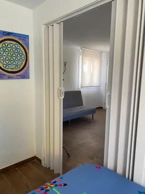 a room with a door open to a room with a bench at “Casa abella “ in Monterrei