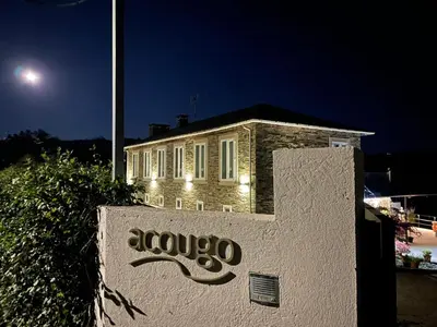 a sign in front of a building at night at Casa Acougo, Sarria in Sarria