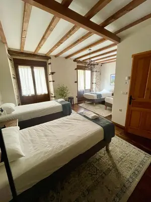 a bedroom with two beds and a couch at Casa El Colibrí in Villafranca del Bierzo