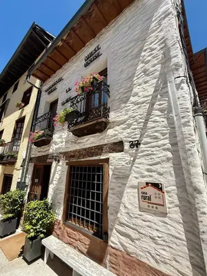 a white building with a sign on the side of it at Casa El Colibrí in Villafranca del Bierzo