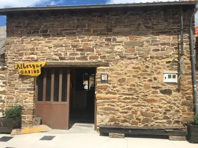 an entrance to a stone building with a door at Albergue Gabino in El Ganso