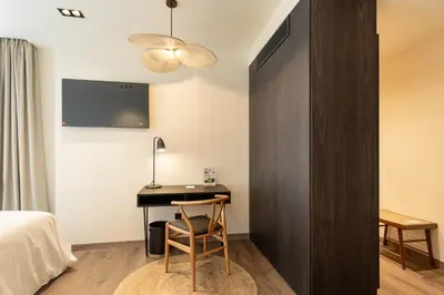 a bedroom with a desk and a bed and a tv at Sercotel EsteOeste in Lugo
