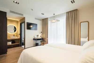 a hotel room with a white bed and a bathroom at Sercotel EsteOeste in Lugo