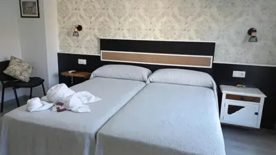 a bedroom with two beds with white towels on them at Lar ABEANCOS in Melide